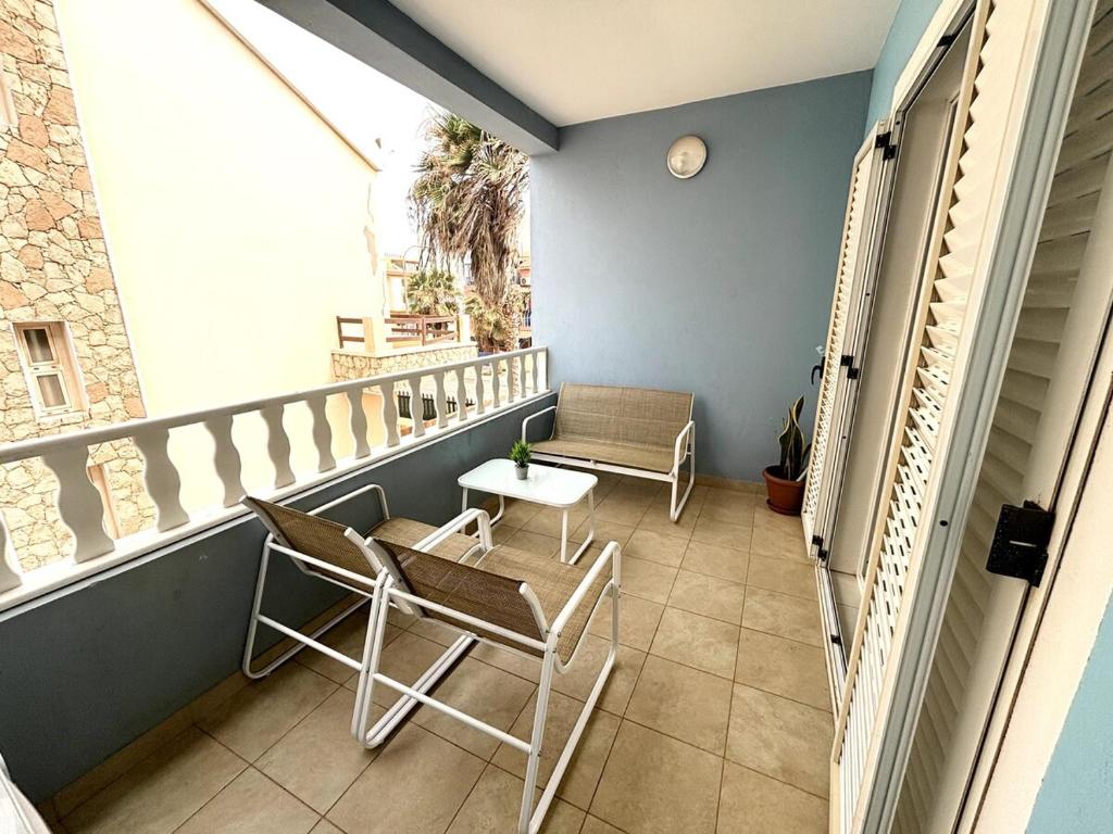 a balcony with chairs and a table and a window at Blue Oceano in Santa Maria