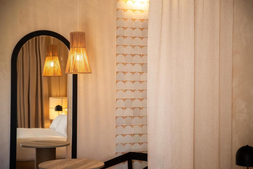 a bedroom with a bed and a mirror and a table at Cala Ponte, a Tribute Portfolio Hotel in Polignano a Mare