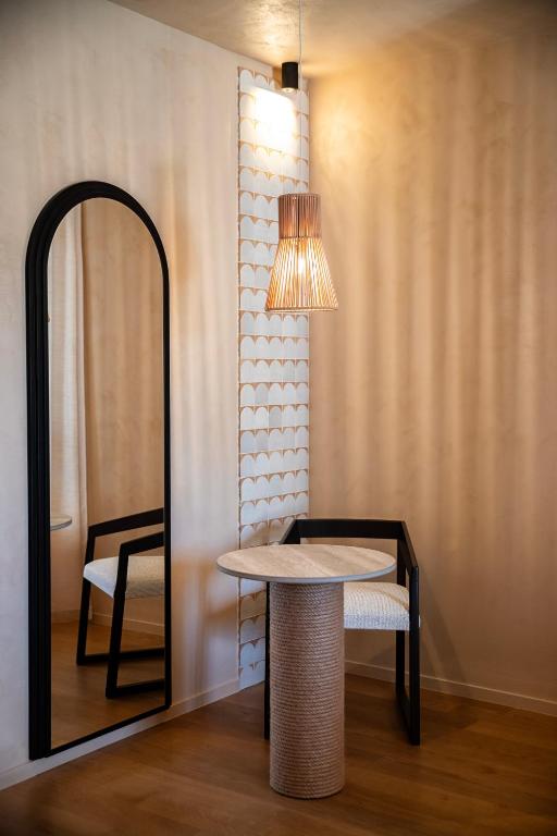 a table and a chair next to a mirror at Cala Ponte, a Tribute Portfolio Hotel in Polignano a Mare