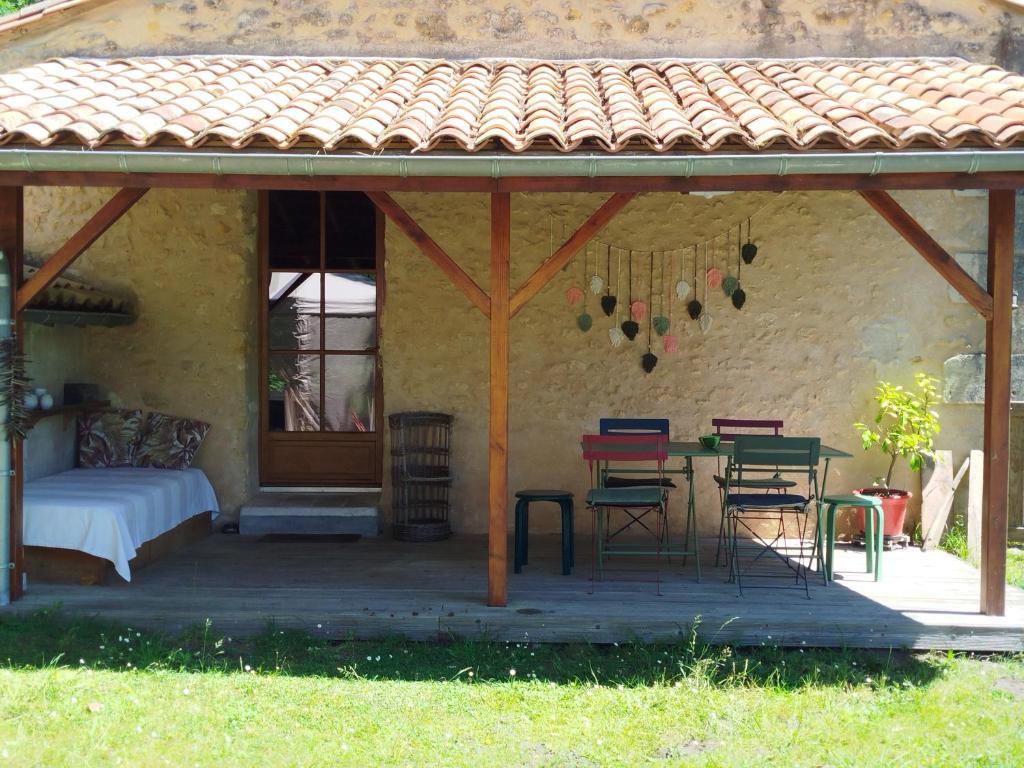 un patio avec une table, des chaises et un lit dans l'établissement Splendide villa en pleine nature avec SPA proche lac, et océan, à Sainte-Hélène