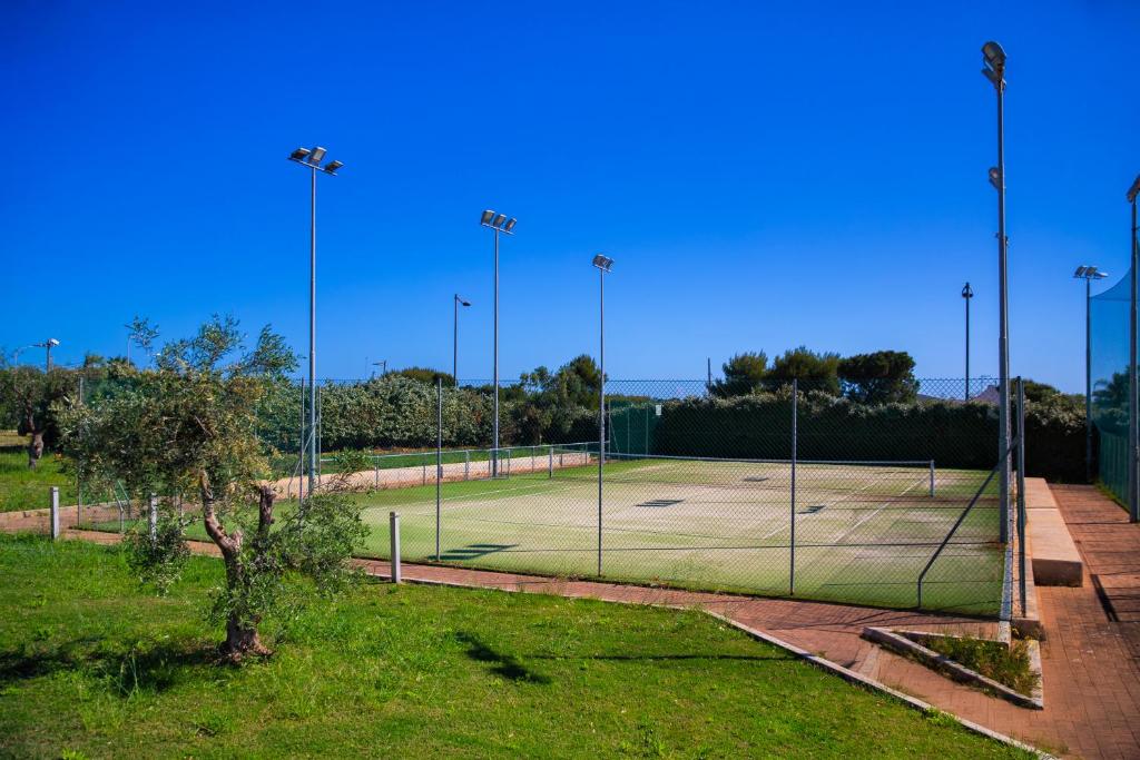a tennis court with a net in a field at Cala Ponte, a Tribute Portfolio Hotel in Polignano a Mare