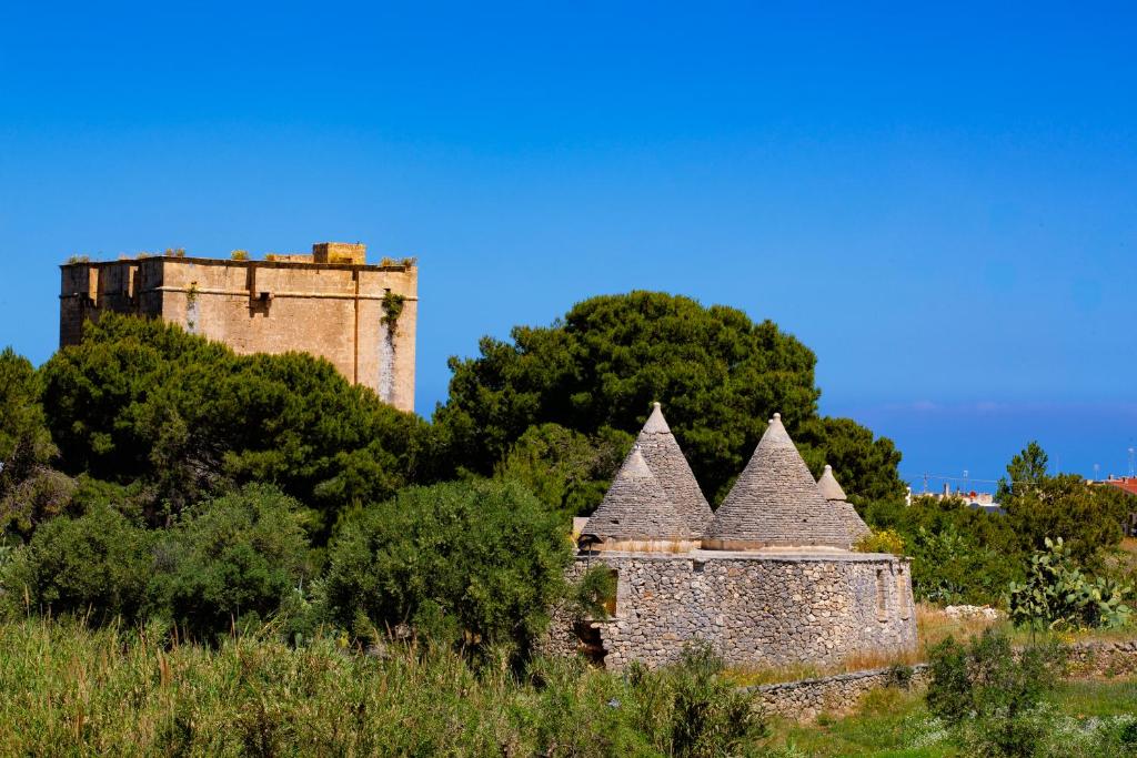 an old castle sitting on top of a hill at Cala Ponte, a Tribute Portfolio Hotel in Polignano a Mare
