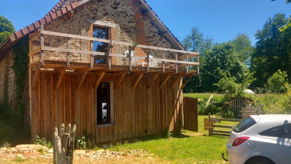 une petite maison avec une voiture garée devant elle dans l'établissement Ferme La Petite Verte, à Saint-Pierre-de-Frugie