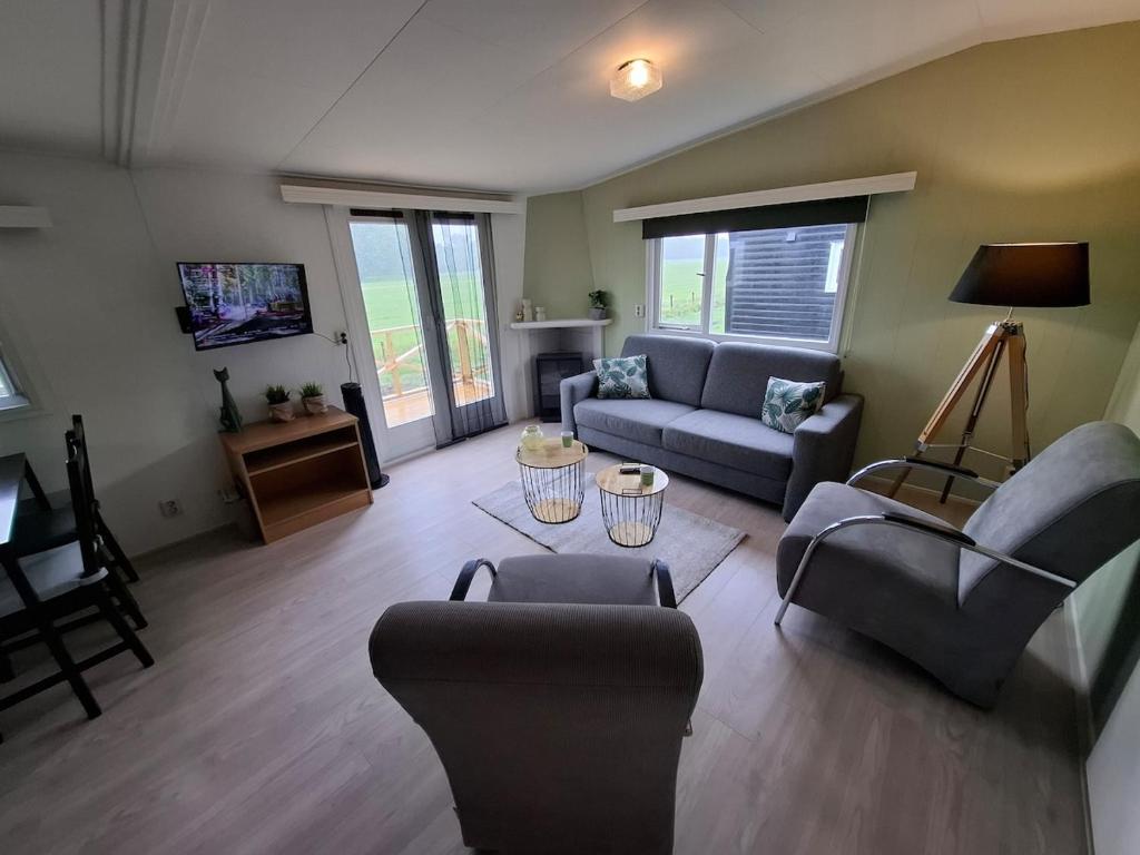 Una sala de estar con dos sofás y una mesa. en Rural holiday home, en Boornbergum