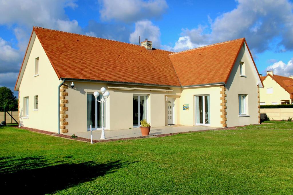 a white house with an orange roof at Villa DES COEURS NORMANDS in Pirou