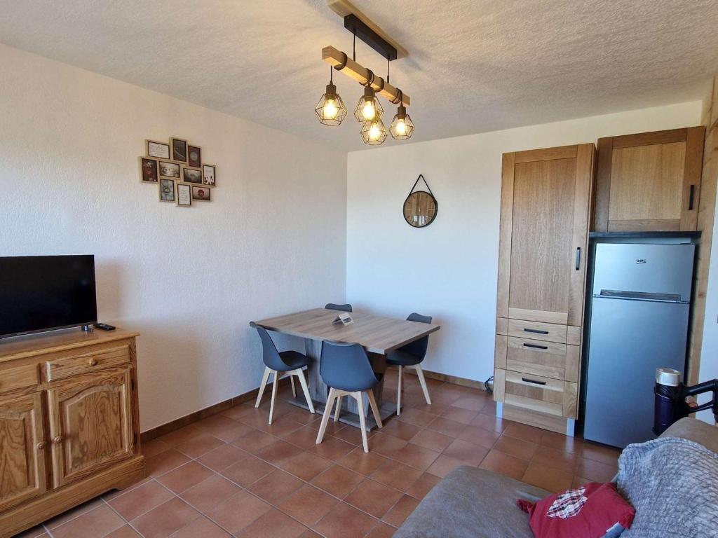 un salon avec une table et un réfrigérateur dans l'établissement Appartement 4 pers - Ski/Rando à pied - Balcon - Animaux admis, Parking - FR-1-393-179, à Saint-Michel-de-Chaillol