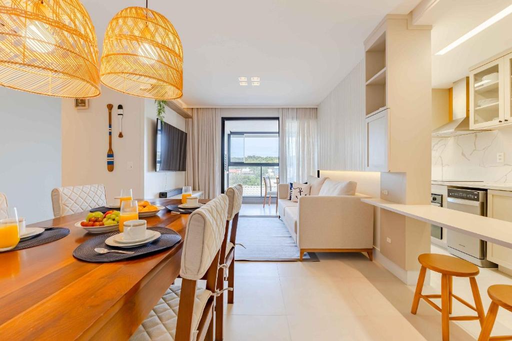a kitchen and dining room with a table and chairs at Apartamento alto padrão com piscina em Bombinhas in Bombinhas
