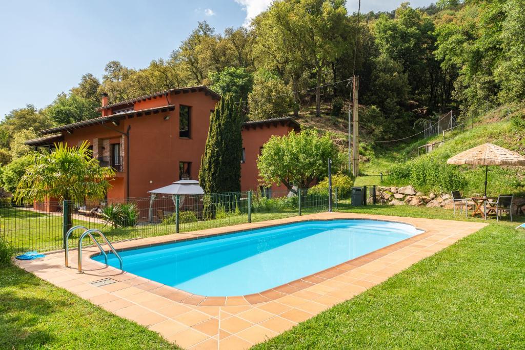 a swimming pool in the yard of a house at Ca la Montse in Viladrau