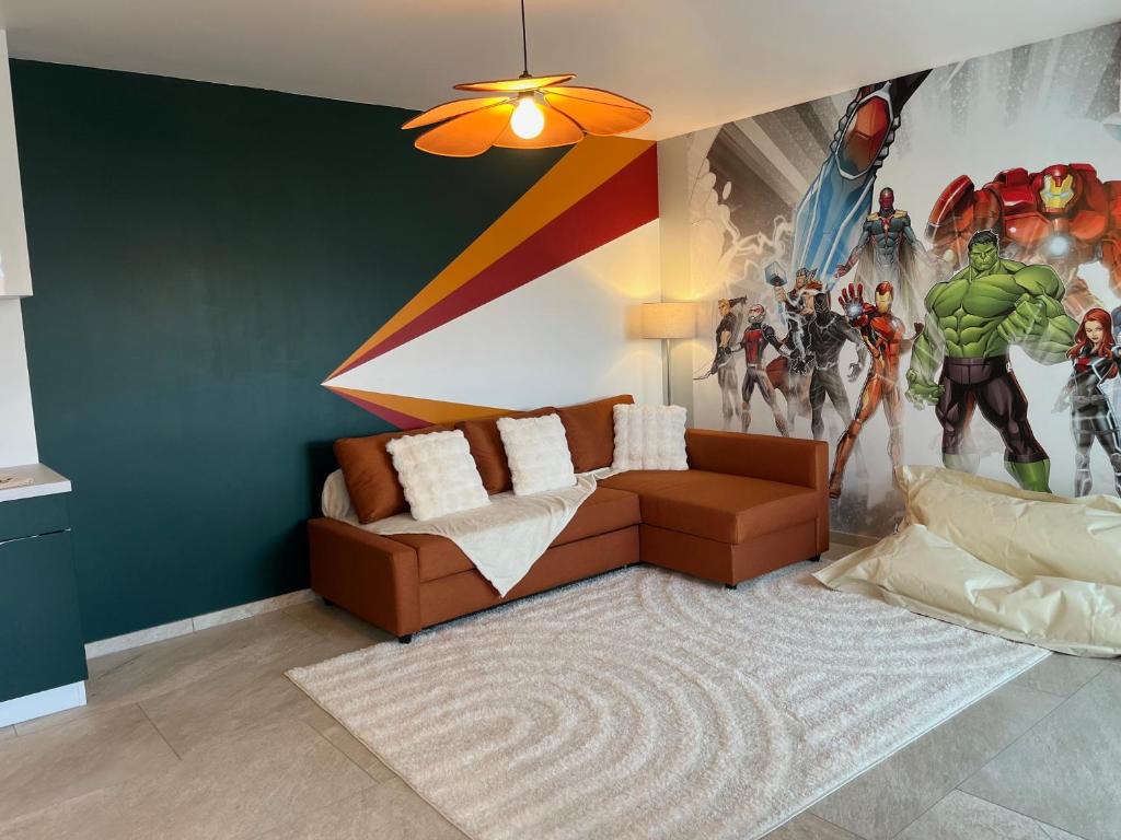 sala de estar con sofá y un mural maravilloso en Le repaire des Supers Héros, en Thannenkirch