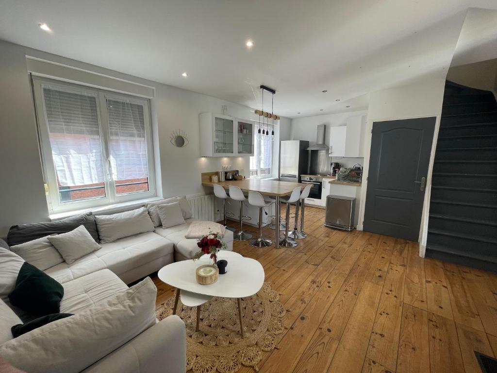 ein Wohnzimmer mit einer weißen Couch und einem Tisch in der Unterkunft Le Duplex Marquettois - 3 chambres in Saint-André