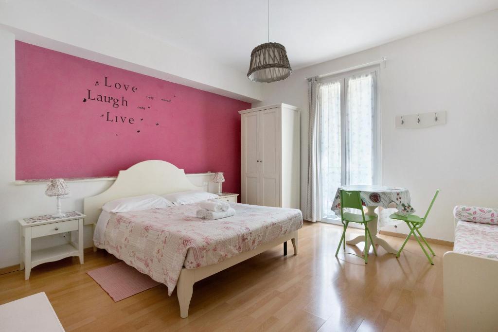 a bedroom with a pink accent wall and a bed at Casa Lorelei in Riomaggiore