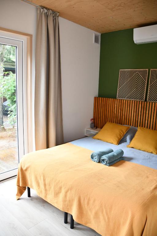a bedroom with a large bed and a window at Black Cabin Veluwe - Wellness in het bos - Airco & Sauna in Putten