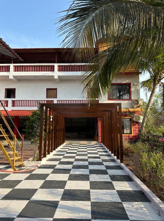 a tunnel leading to a house with a palm tree at Golden bliss Resort and Pool in Nagaon