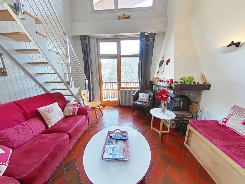 un salon avec un canapé rouge et une table dans l'établissement Appartement 3 pièces, 7 couchages, Le Grand-Bornand - FR-1-241-203, au Grand-Bornand