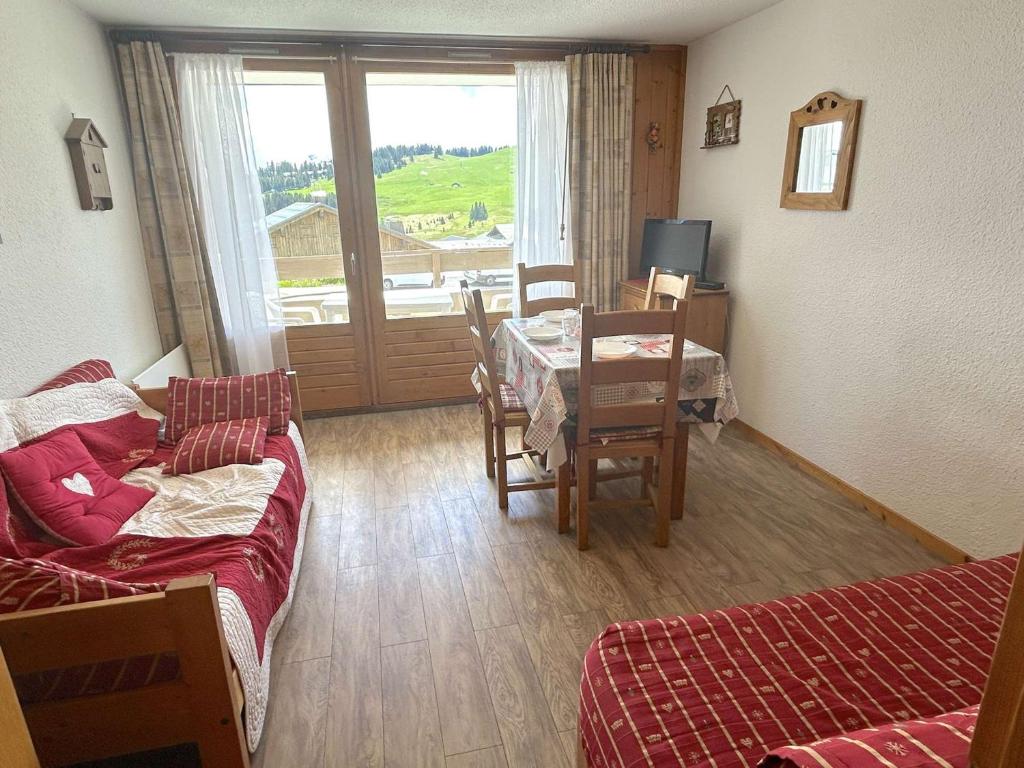 - un salon avec un canapé, une table et une salle à manger dans l'établissement Studio cabine au centre des Saisies avec balcon, pour 5 personnes, proche commerces, exposé sud - FR-1-594-109, à Hauteluce