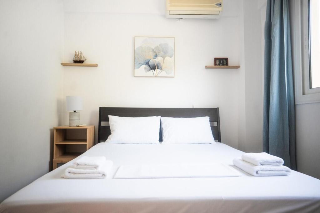 a bedroom with a white bed with towels on it at Mola Kaliva Seaview Retreat in Mola Kalyva