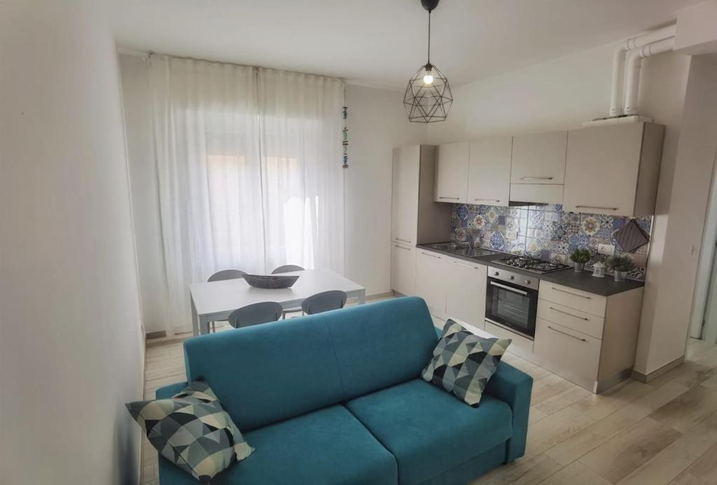 a living room with a blue couch and a kitchen at A casa di Azzurra in Roseto degli Abruzzi