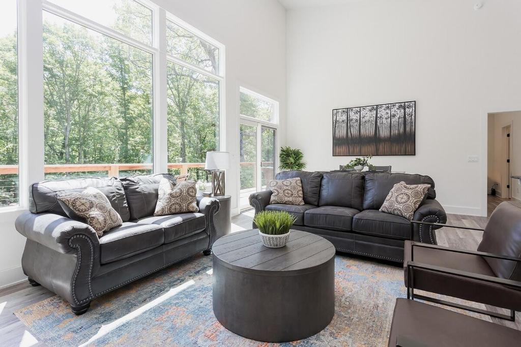 a living room with two couches and a table at Flo Ride Chalet Hot tub Woodland viewsOn the Back 40 trail in Bella Vista