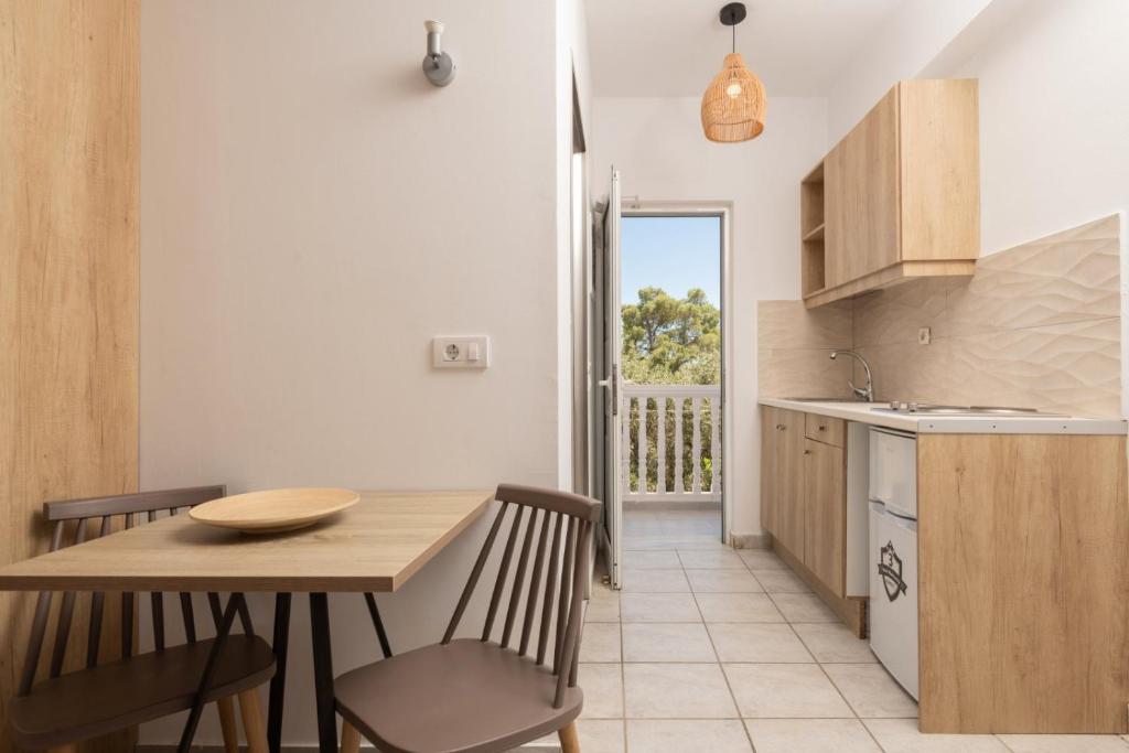 a kitchen and dining room with a table and chairs at Akis Studios Alykes in Alykes
