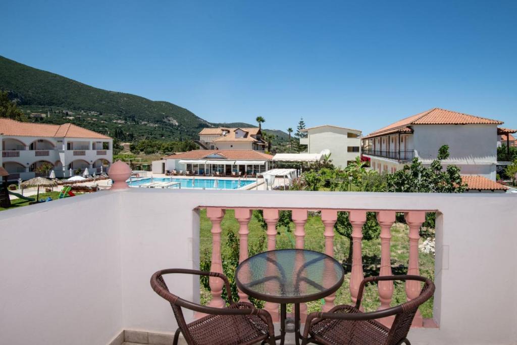 a chair on a balcony with a view of a pool at Akis Studios Alykes in Alykes