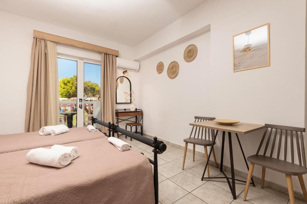 a bedroom with a bed and a table and a window at Akis Studios Alykes in Alykes