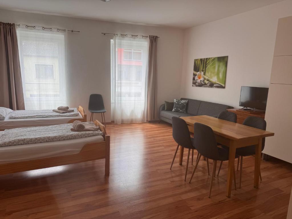 a room with two beds and a table and a couch at Apartment im Herzen von Neusiedl am See in Neusiedl am See