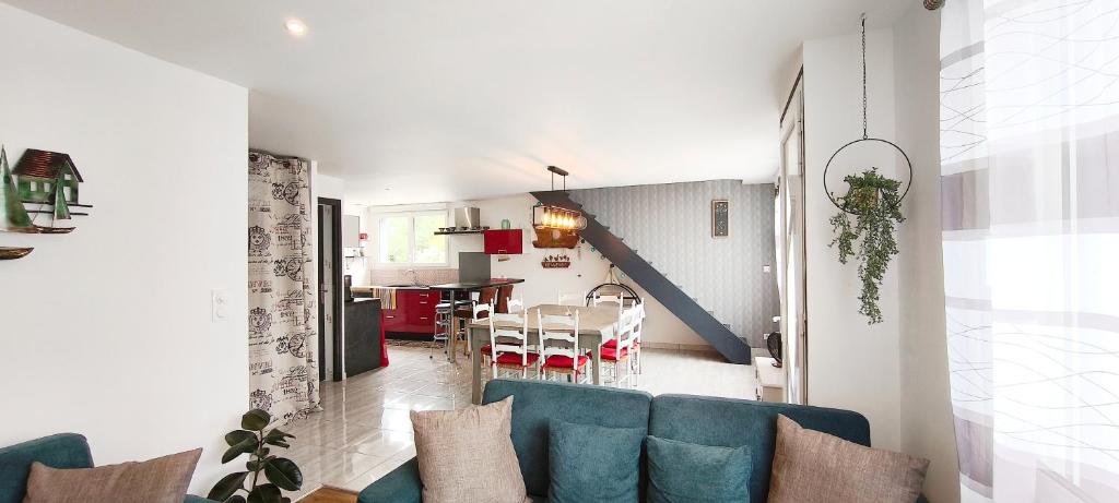 un salon avec un canapé bleu et une salle à manger dans l'établissement L'Echappée Bretonne, à Erdeven