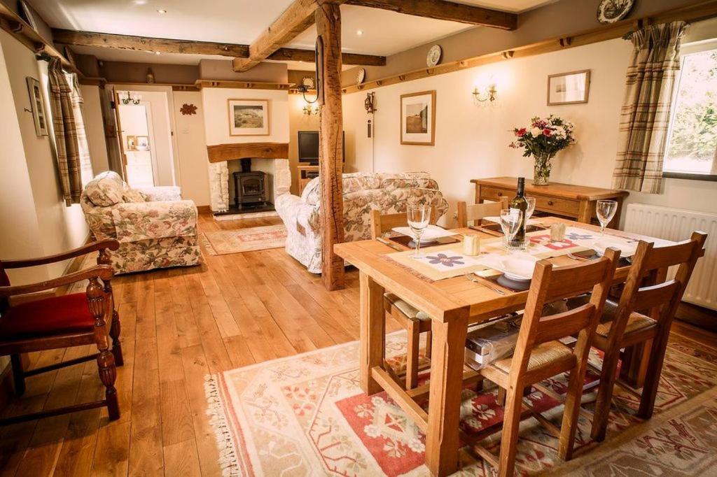 a dining room with a table and a living room at Charming Welsh Cottage in Johnston