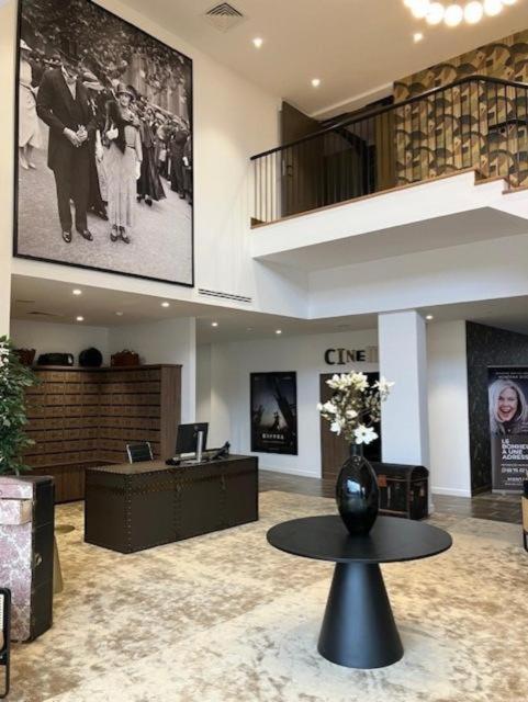 a lobby with a vase of flowers on a table at Montana Dijon in Dijon