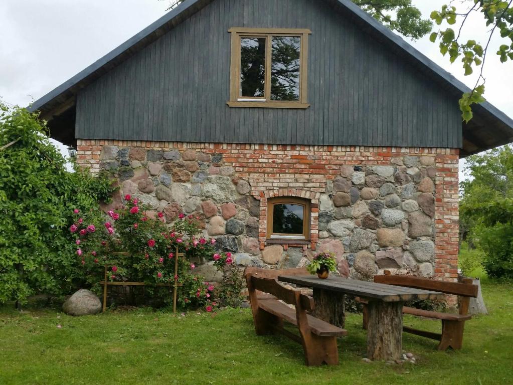 - un bâtiment en pierre avec un banc et une fenêtre dans l'établissement Brīvdienu māja Ievkalni, à Jūrkalne