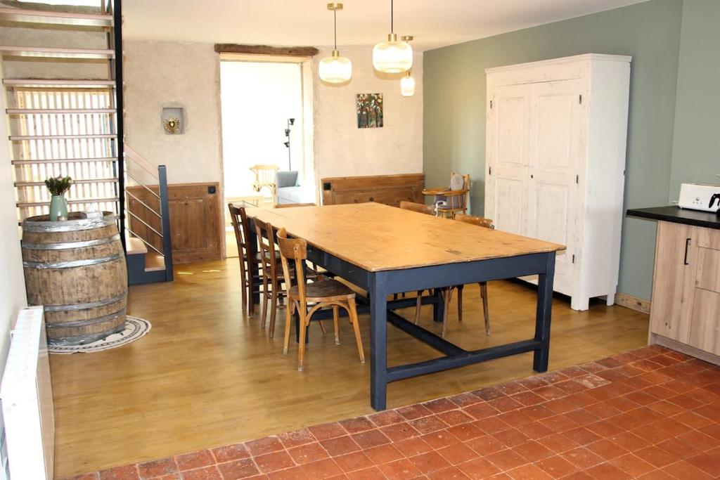 a dining room with a table and chairs in a room at La Bauderie in Bussières