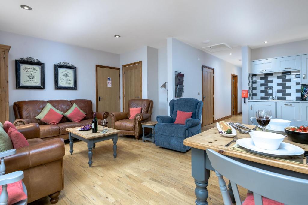 ein Wohnzimmer mit Ledermöbeln und einem Tisch in der Unterkunft Beech Cottage in Boston