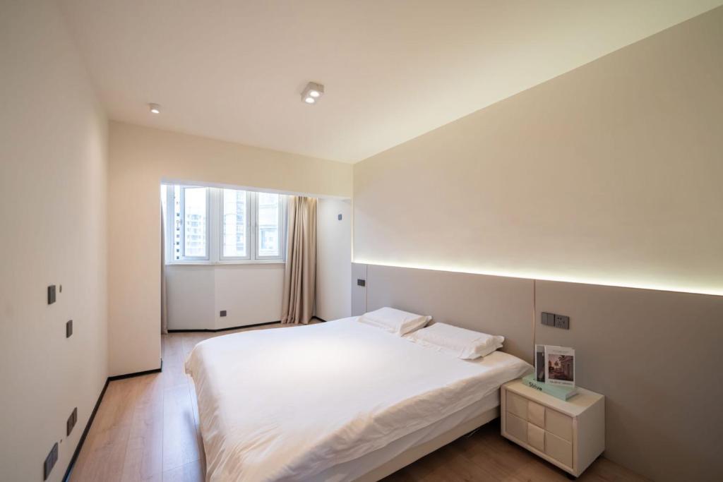 上海Pure home-Luxurious Grand Penthouse in Shanghai Core,Large area,close to Yu Garden The Bund People Square Commanding Panoramic Night of the Pearl Tower,Enjoying the stunning views of the Bund的卧室配有白色的床和窗户。