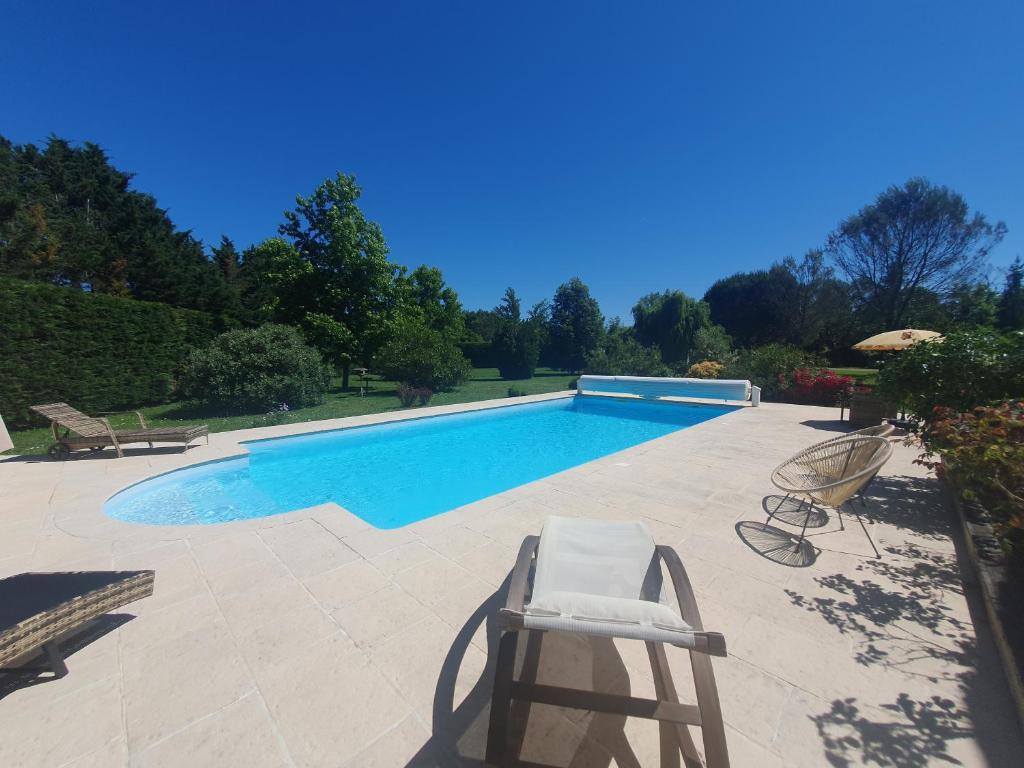 - une piscine avec 2 chaises et un sauna dans l'établissement Suite climatisée avec entrée privative Les deux glycines, à Lédat