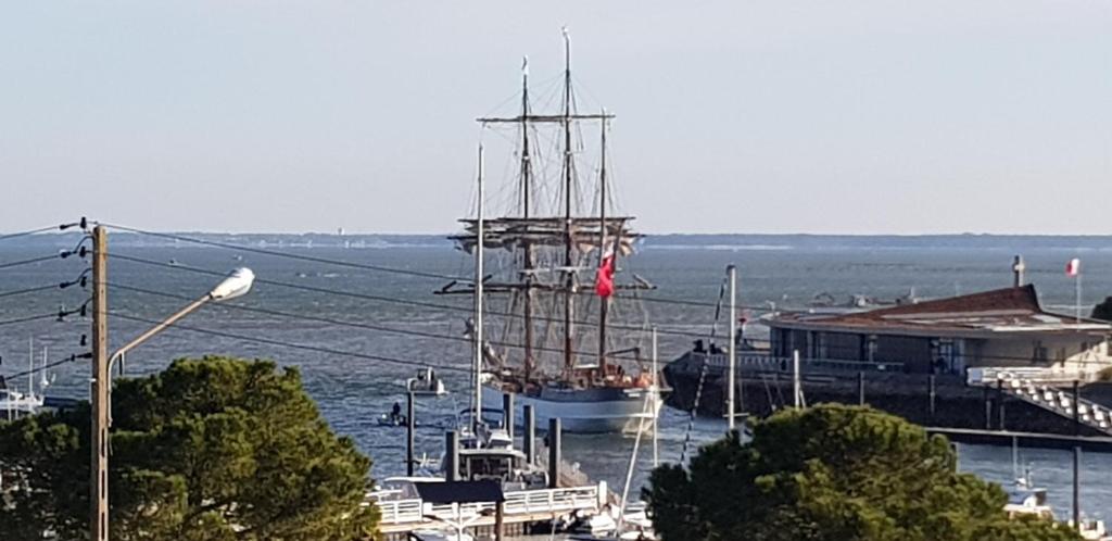 un bateau est amarré à un quai dans l'eau dans l'établissement T2 très belle vue bassin avec balcon 100 m plage, à Arcachon