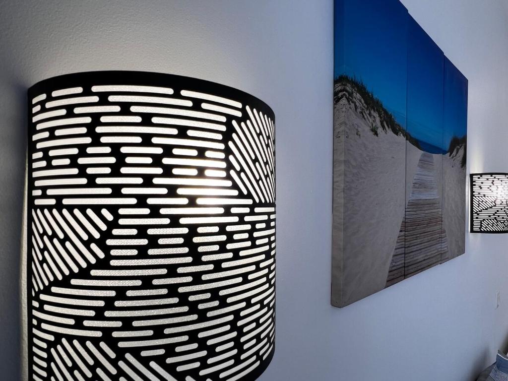 un vase noir et blanc sur un mur avec une photo dans l'établissement T2 Cosy, Piscine, Parking et Résidence front mer, à Les Sables-dʼOlonne