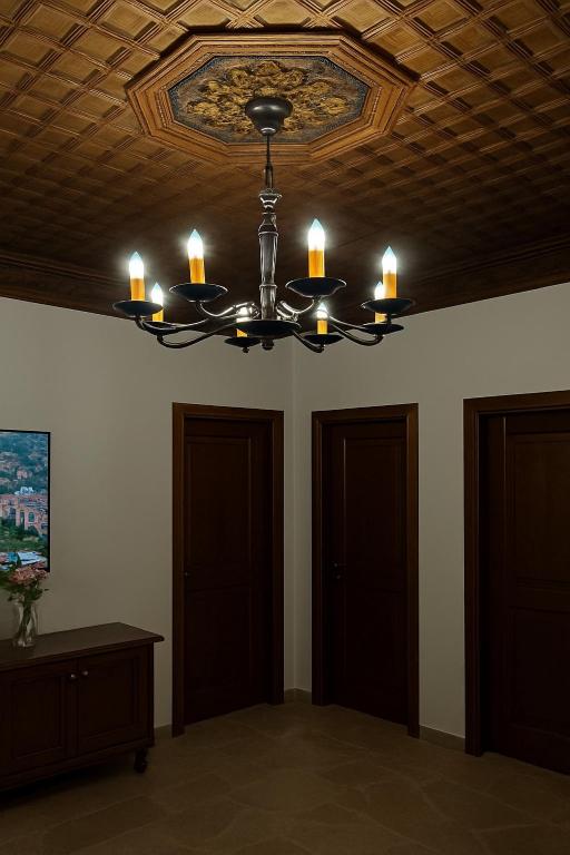 a chandelier with candles on a ceiling in a room at Villa Merkaj, Berat Castle in Berat