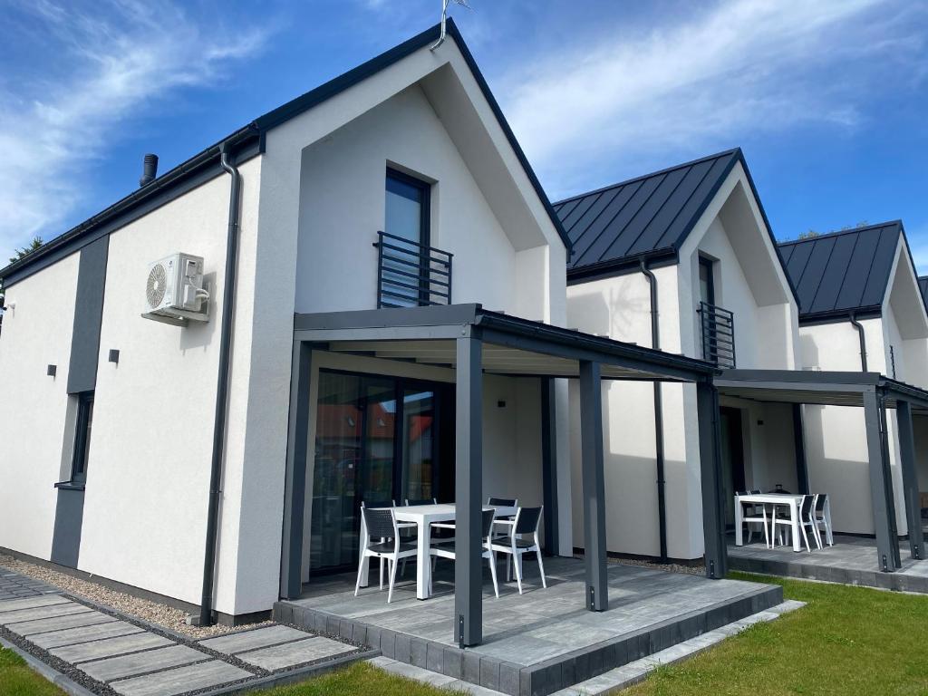 a white house with a table and chairs at Sorella House in Sianozety