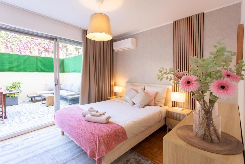 - une chambre avec un lit et un vase avec des fleurs roses dans l'établissement 86m- Spacious 3 room apartment with large terrace, à Villefranche-sur-Mer