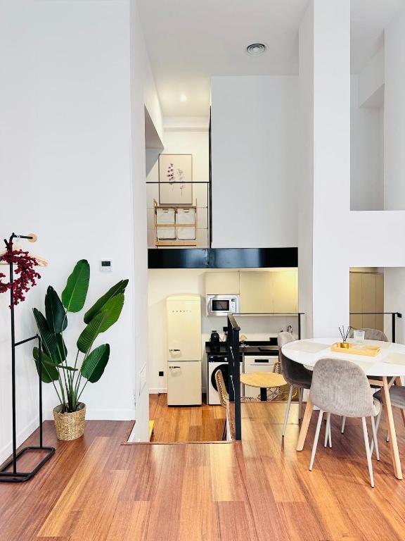 Una cocina y un comedor con mesa y sillas. en Confort Moderno Encantador Loft Las Ventas, en Madrid