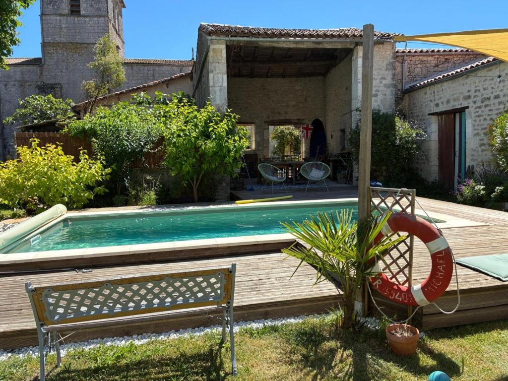- une piscine dans une cour avec un banc à côté dans l'établissement Le Cottage, à Foussignac