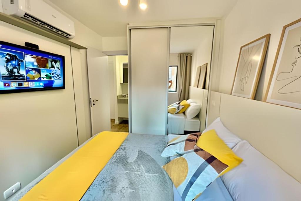 a bedroom with a bed and a tv on the wall at #Sensacional# Apto 1 quarto, Pensado Para Voce in Curitiba
