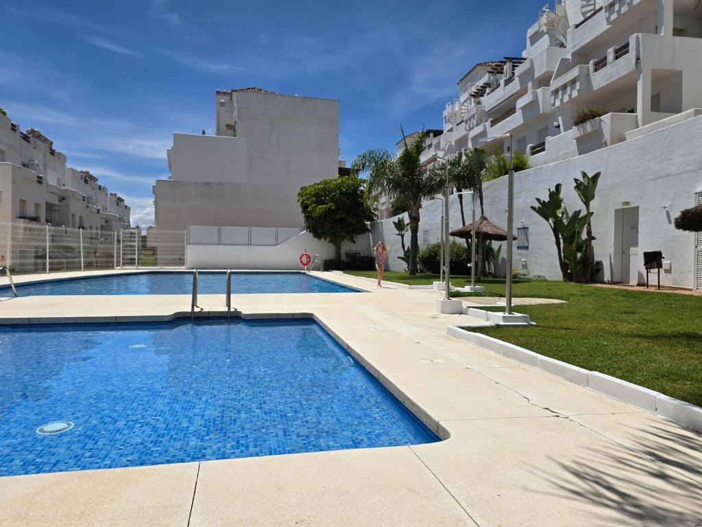 a swimming pool in front of a building at Superior Golf and Holiday Penthouse in Costa del Sol in Estepona
