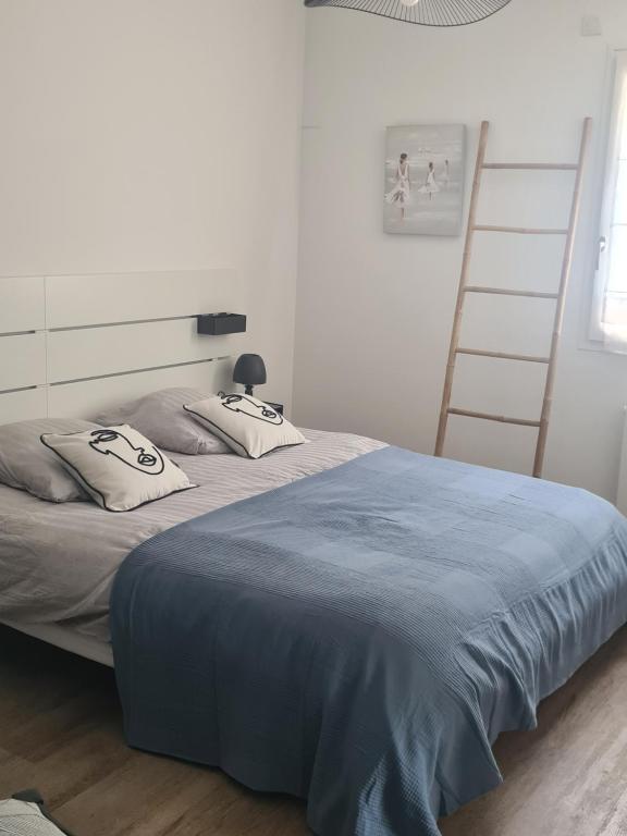 a bedroom with two beds with blue sheets and a ladder at Maison hyper centre in Dol-de-Bretagne