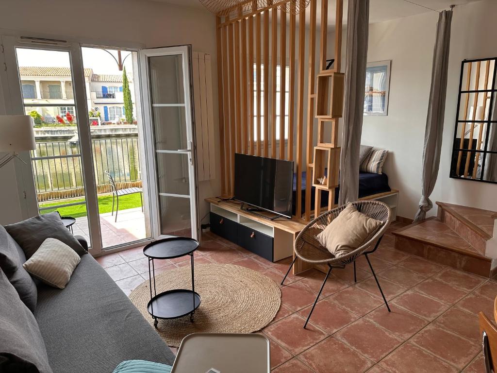 un salon avec un canapé et une télévision dans l'établissement Charmante maison de pêcheur, à Aigues-Mortes