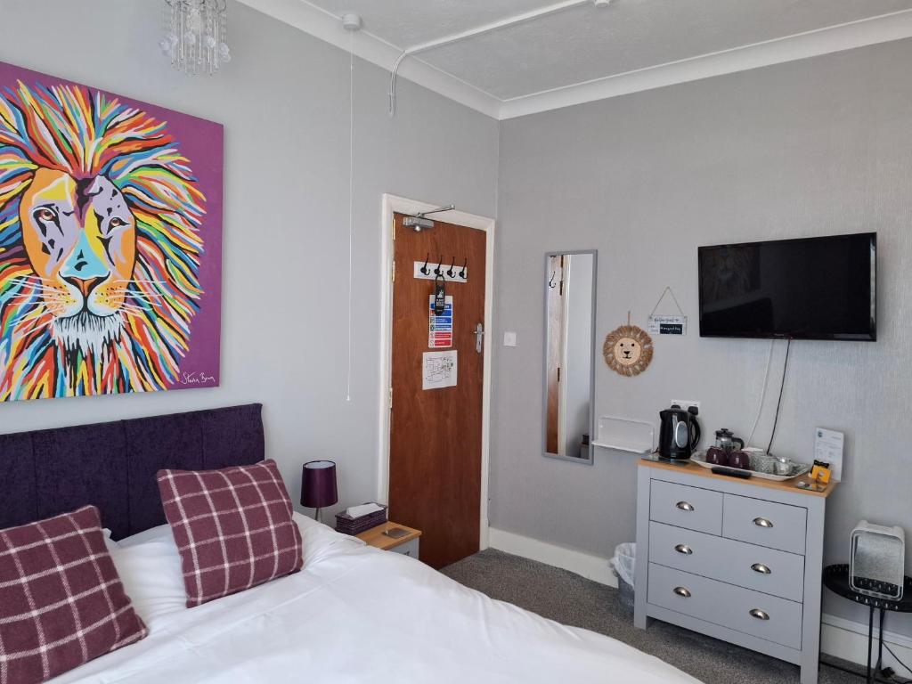 a bedroom with a bed and a painting of a lion at Westbrook Lodge Guest House in Margate
