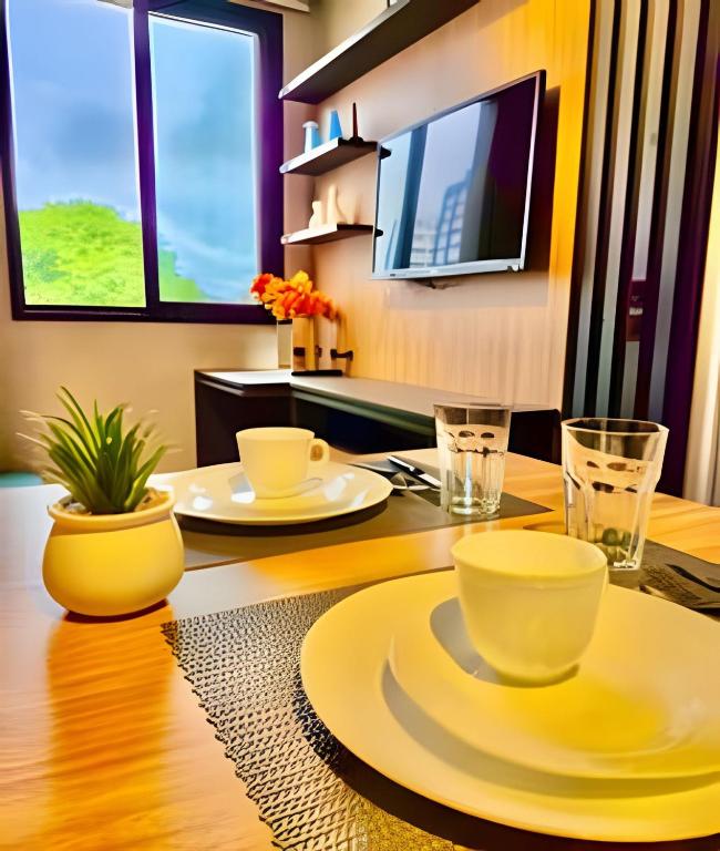 a dining room table with yellow plates and cups on it at VERSáTIL - Apto de 1 quarto in Curitiba