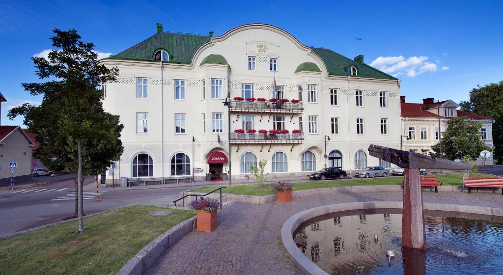un grand bâtiment avec une fontaine devant lui dans l'établissement Clarion Collection Hotel Post, à Oskarshamn