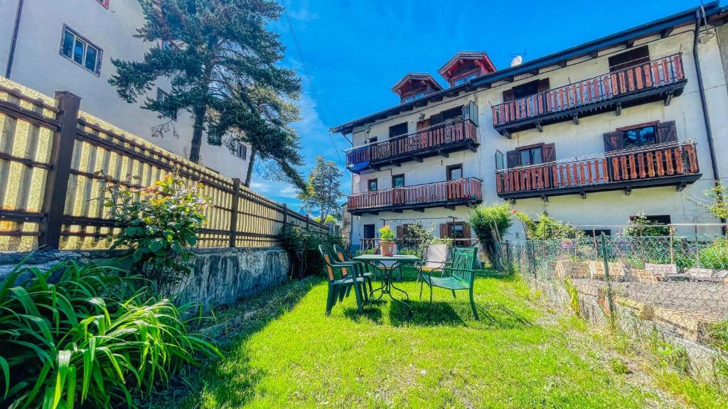 a yard with a table and chairs in front of a building at Appartamento Ortigara 16 - Affitti Brevi Italia in Oulx