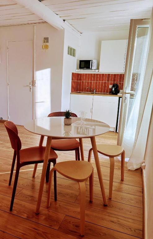 - une table et des chaises dans une pièce avec cuisine dans l'établissement Le Nid des Salins - Studio Mer & Terrasse, à Hyères